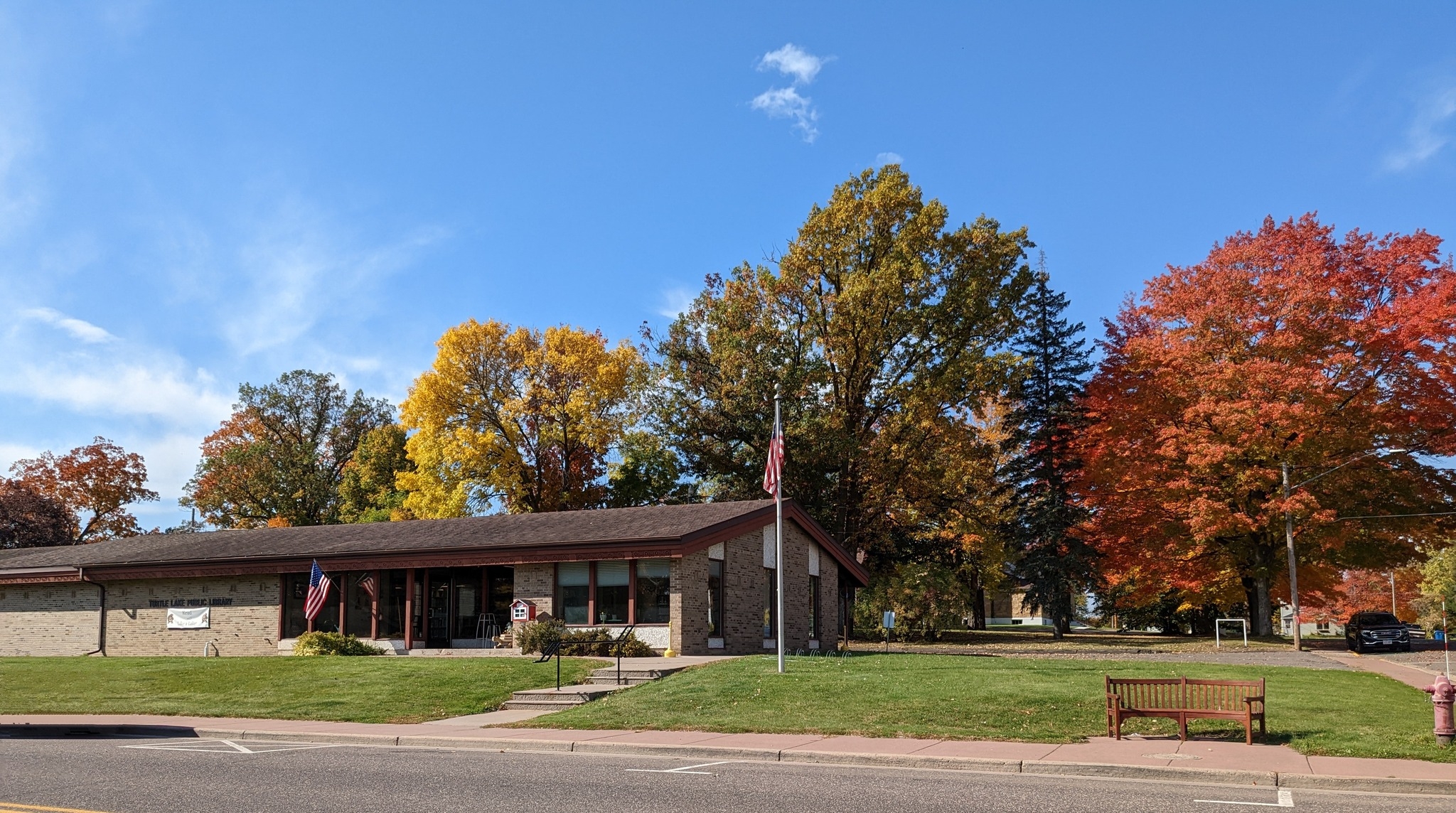 The Turtle Lake Public Library building with autumn leaves